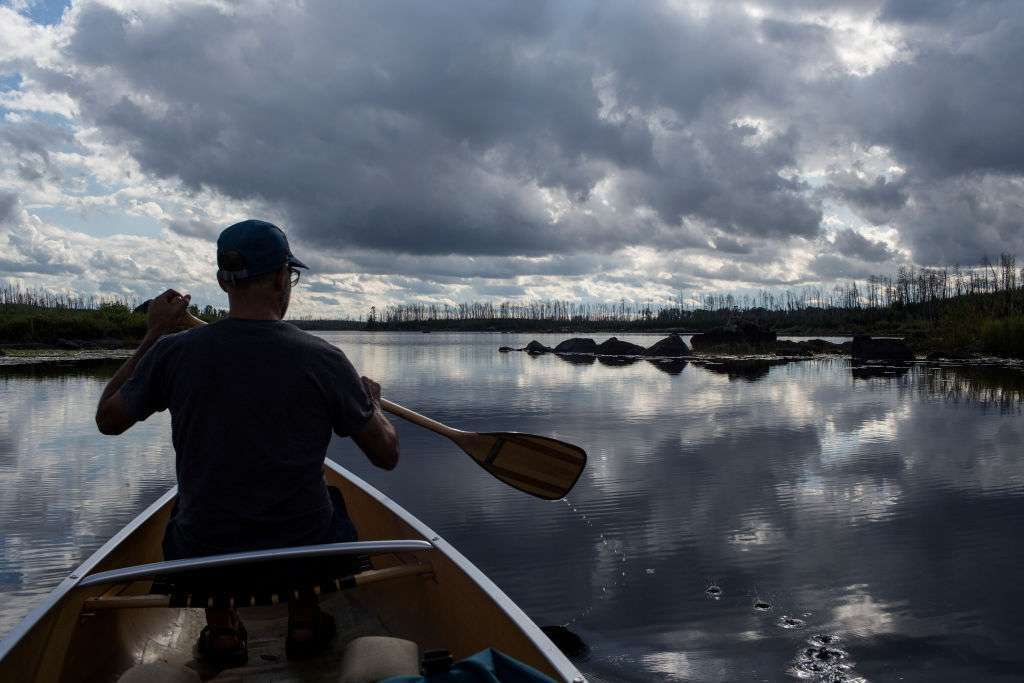 Outdoor enthusiasts travel by canoe through several of the hundreds of fresh water lakes that make up the Boundary Waters.