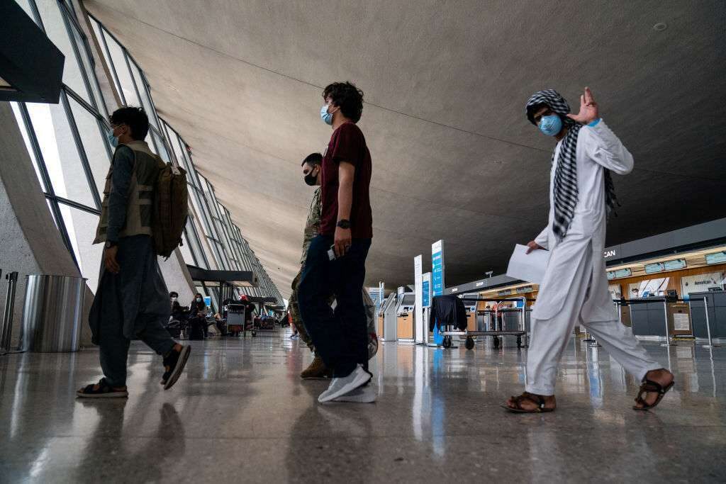 Evacuees who fled Afghanistan walk through Dulles International Airport in August. 