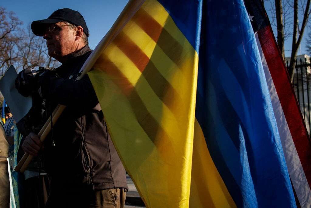 A pro-Ukrainian activist holds an American and Ukrainian flag together as activists gathered for a prayer in front of the White House on Feb. 6. 