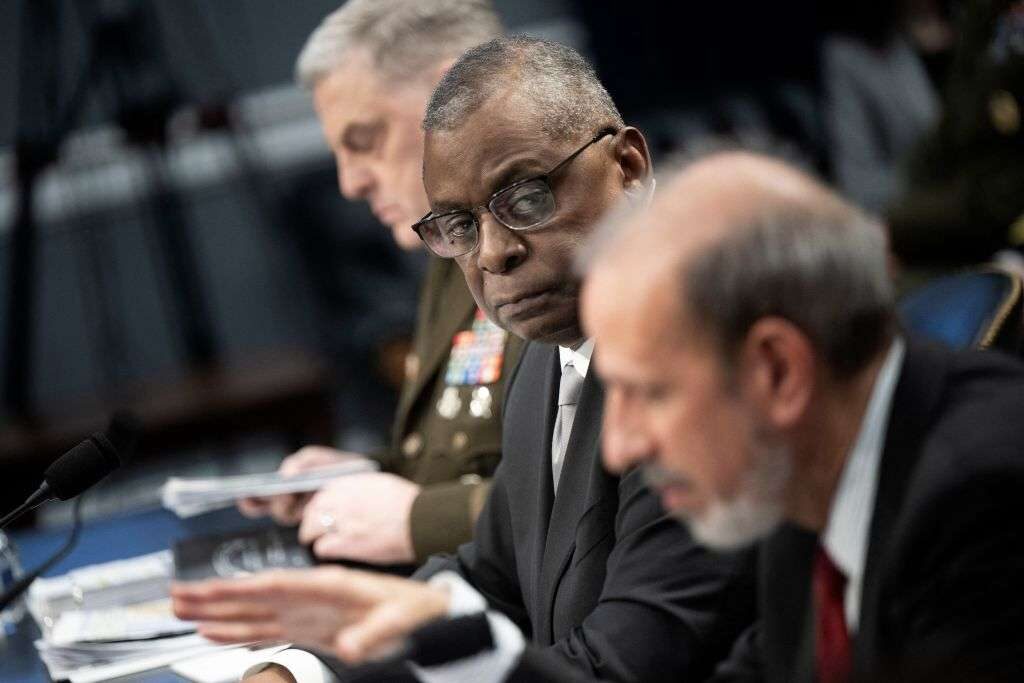 Chairman of the Joint Chiefs of Staff Gen. Mark Milley, left, and Defense Secretary Lloyd J. Austin III, center, listen as Defense Comptroller Michael J. McCord speaks during a House hearing in May. Austin has made confronting the challenge of sexual crimes in the military a centerpiece of his tenure. 