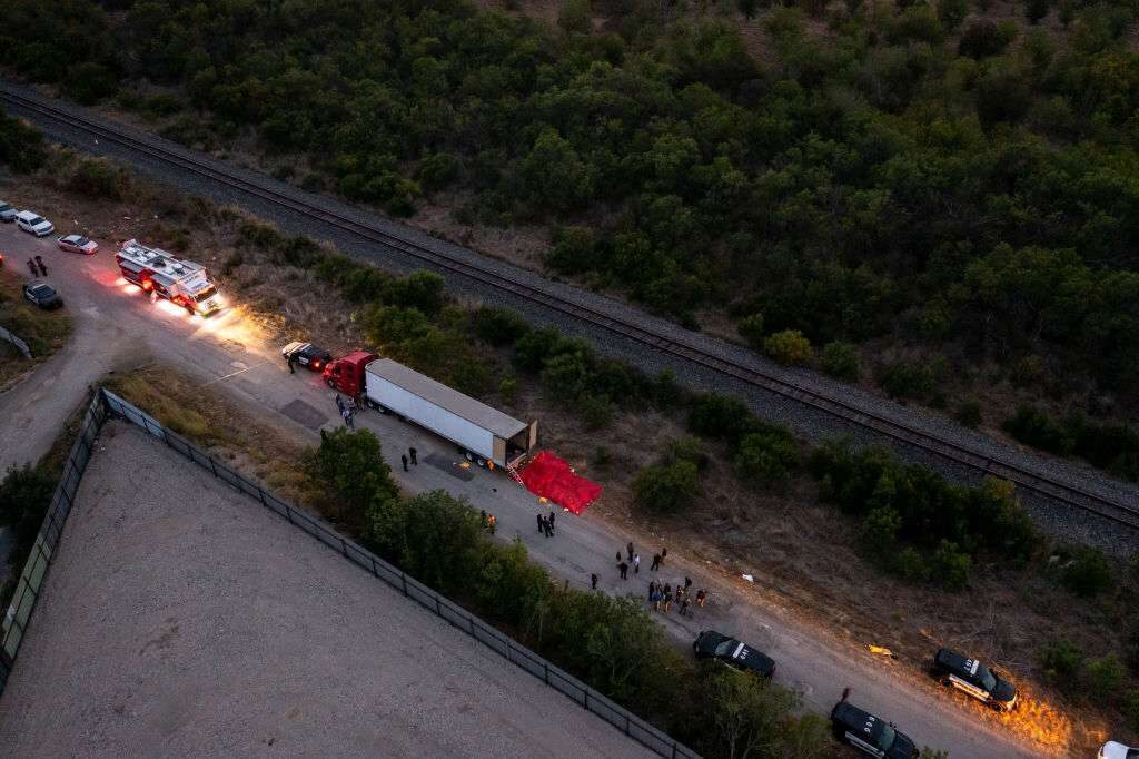 Members of law enforcement investigate a tractor trailer on Monday in San Antonio. According to reports, at least 46 people, who are believed migrant workers from Mexico, were found dead in an abandoned tractor trailer. Over a dozen victims were found alive, suffering from heat stroke and taken to local hospitals. 