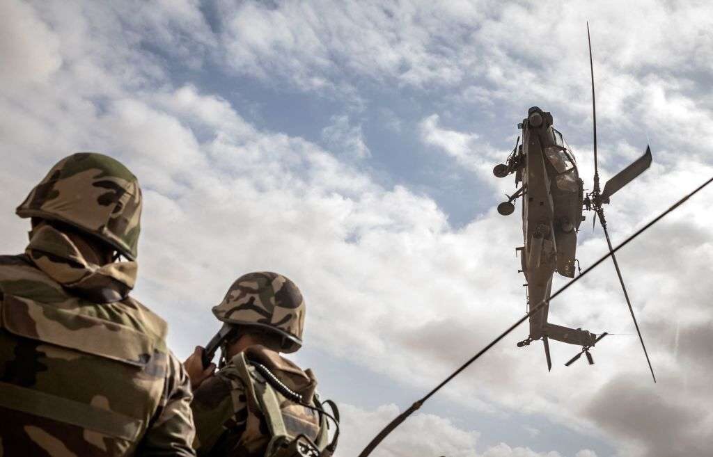 A U.S. Army AH-64 Apache attack helicopter flies over members of the Moroccan Royal Armed Forces during  a military exercise June 30 in southwestern Morocco.