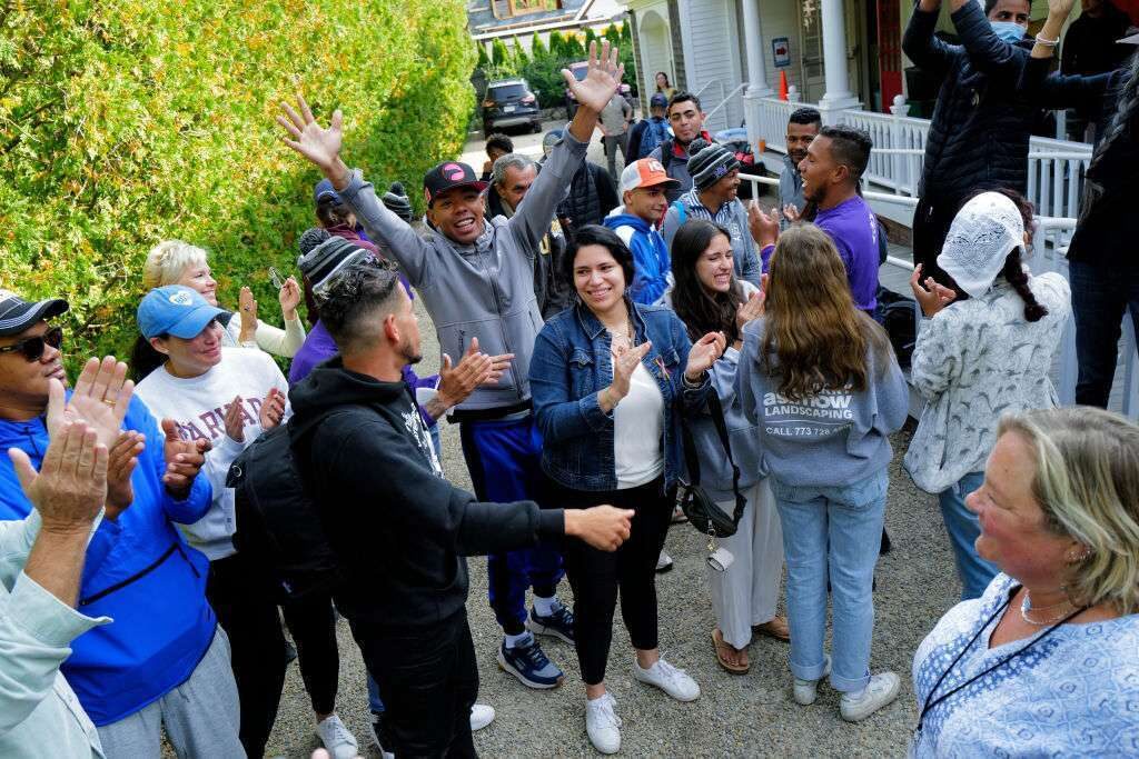 Venezuelan migrants and volunteers celebrate together outside of St. Andrew's Parish House on Martha's Vineyard last week. 