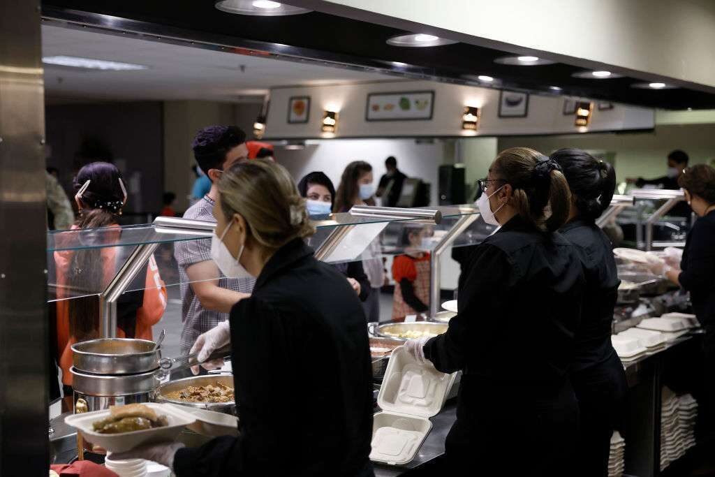 Kitchen staff serve food to Afghan nationals last month in the dining room of the National Conference Center (NCC) in Leesburg, Va., which in recent months has been redesigned to temporarily house Afghan nationals.
