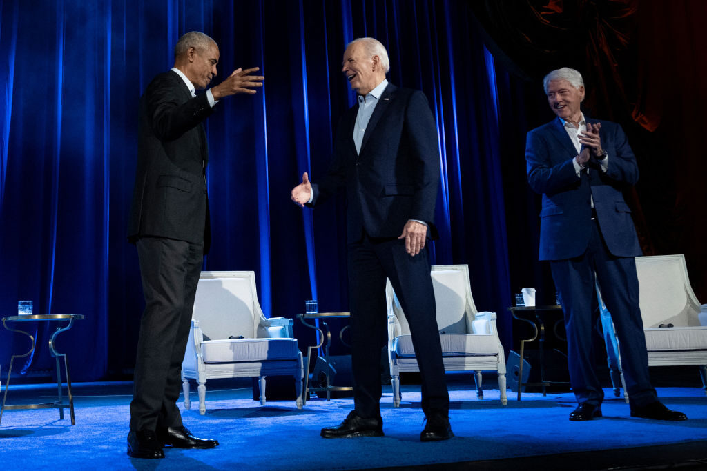 Former President Bill Clinton, far right, watches as former President Barack Obama and President Joe Biden shake hands during a campaign fundraising event at Radio City Music Hall in New York City on Thursday night.