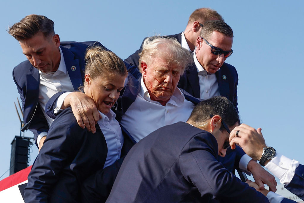 Former President Donald Trump is rushed offstage by Secret Service agents after being grazed by a bullet during a July 13 rally in Pennsylvania.