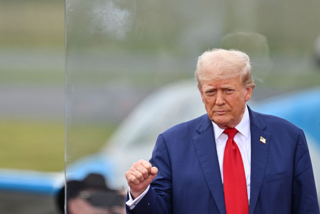 Republican presidential candidate and former President Donald Trump gestures behind bulletproof glass as he concludes his remarks during a campaign rally at the North Carolina Aviation Museum & Hall of Fame in Asheboro on Wednesday.