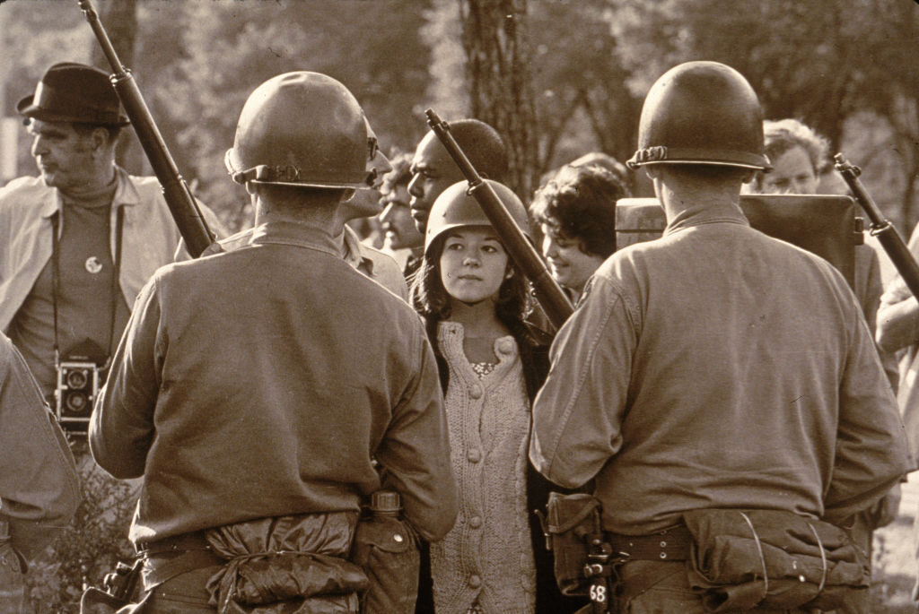 A young female protester wearing a helmet faces down helmeted and armed police officers at an anti-Vietnam War demonstration outside the 1968 Democratic National Convention in Chicago in August 1968. (Hulton Archive/Getty Images)