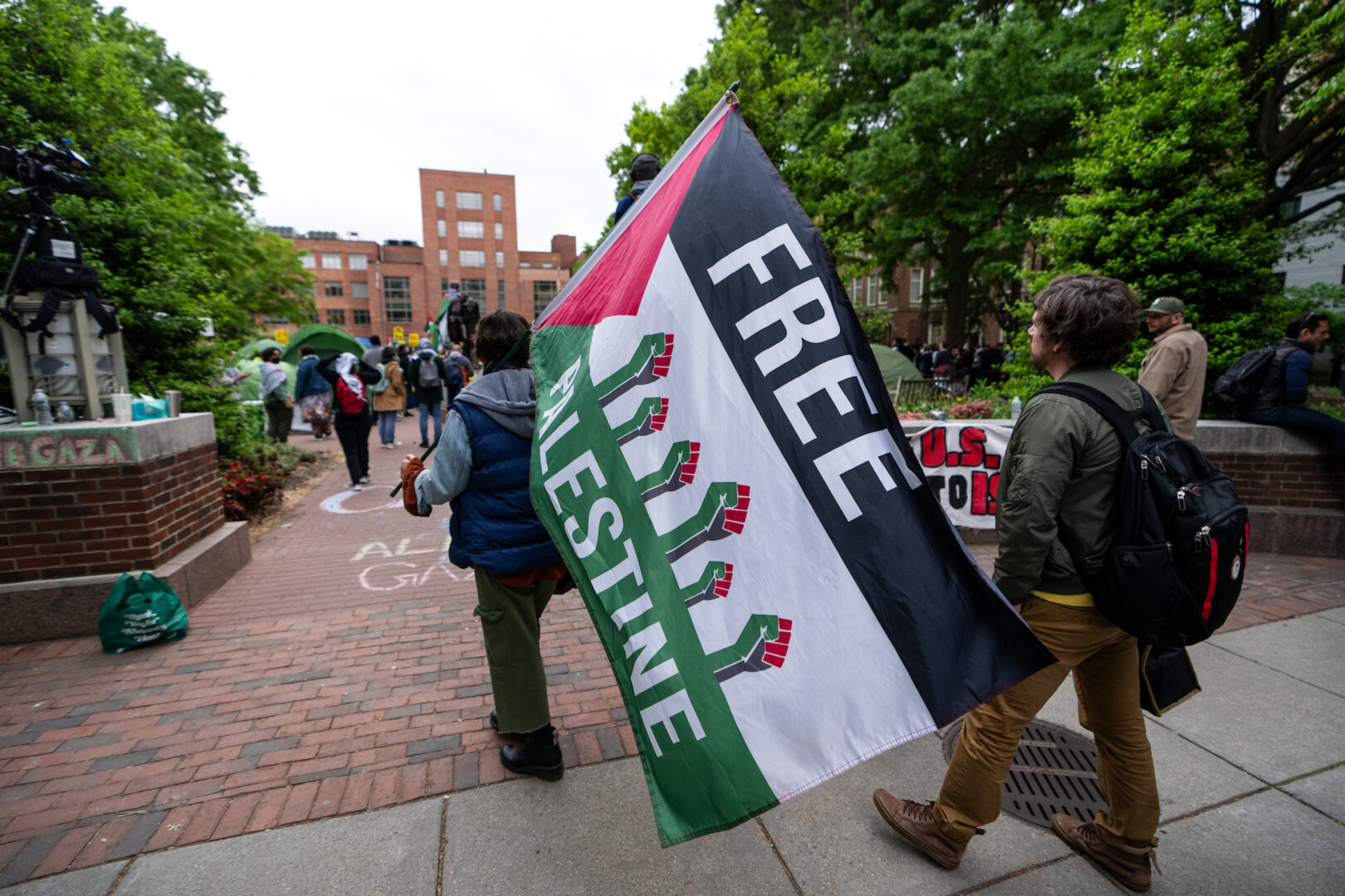 Activists carry a “Free Palestine” flag into an encampment at George Washington University on April 25.