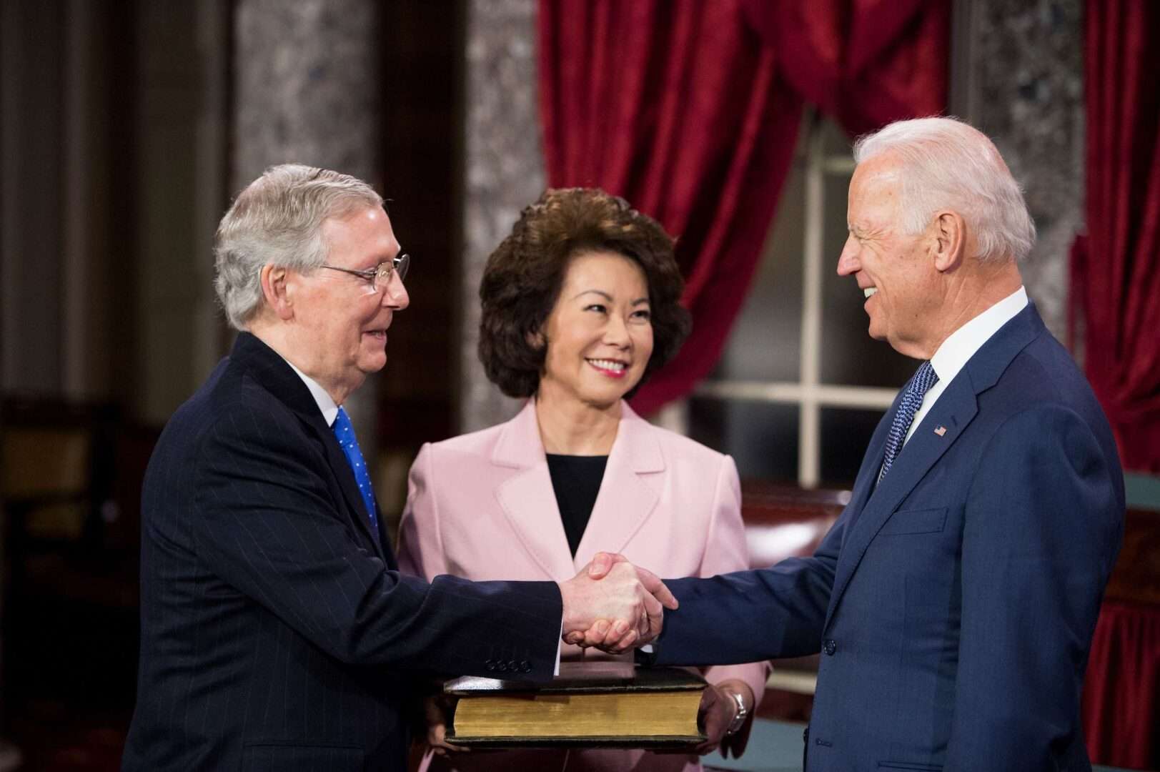 The relationship between Senate Minority Leader Mitch McConnell, left, and President Joe Biden goes back decades. They are pictured here along with McConnell's wife, Elaine Chao, during a reenactment swearing-in ceremony on Jan. 6, 2015.