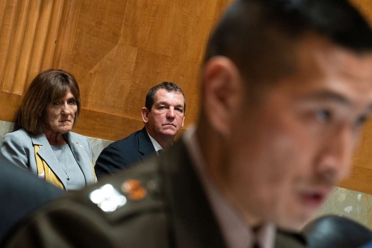 Paula Cook and Richard C. Taylor, executives at Balfour Beatty Communities, look on as Army Capt. Samuel Choe testifies about health problems his daughter developed while living in a Balfour Beatty home.