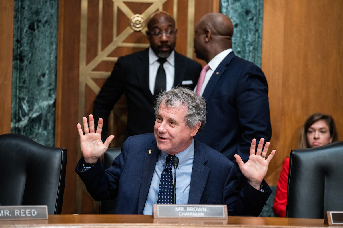 Sen. Sherrod Brown, D-Ohio, reacts during a Senate Banking Committee hearing on Thursday. Brown is in a toss-up reelection race that will be key to who is in the majority in the next Congress. Also pictured are, left, Sens. Raphael Warnock, D-Ga., and Tim Scott, R-S.C.