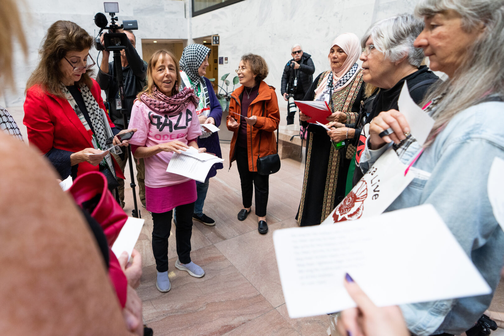 CodePink’s Medea Benjamin, center left, sings with other activists in the Hart Senate Office Building atrium on Thursday as they call on female senators support a cease-fire in Gaza.