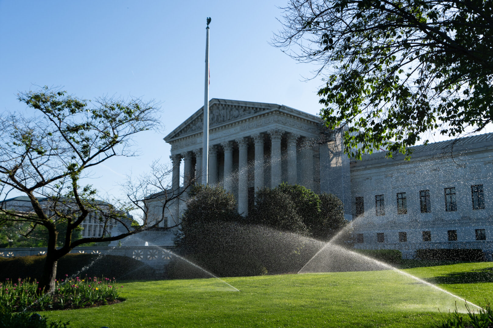 Sprinklers water the lawn in front of the Supreme Court on Monday morning. 