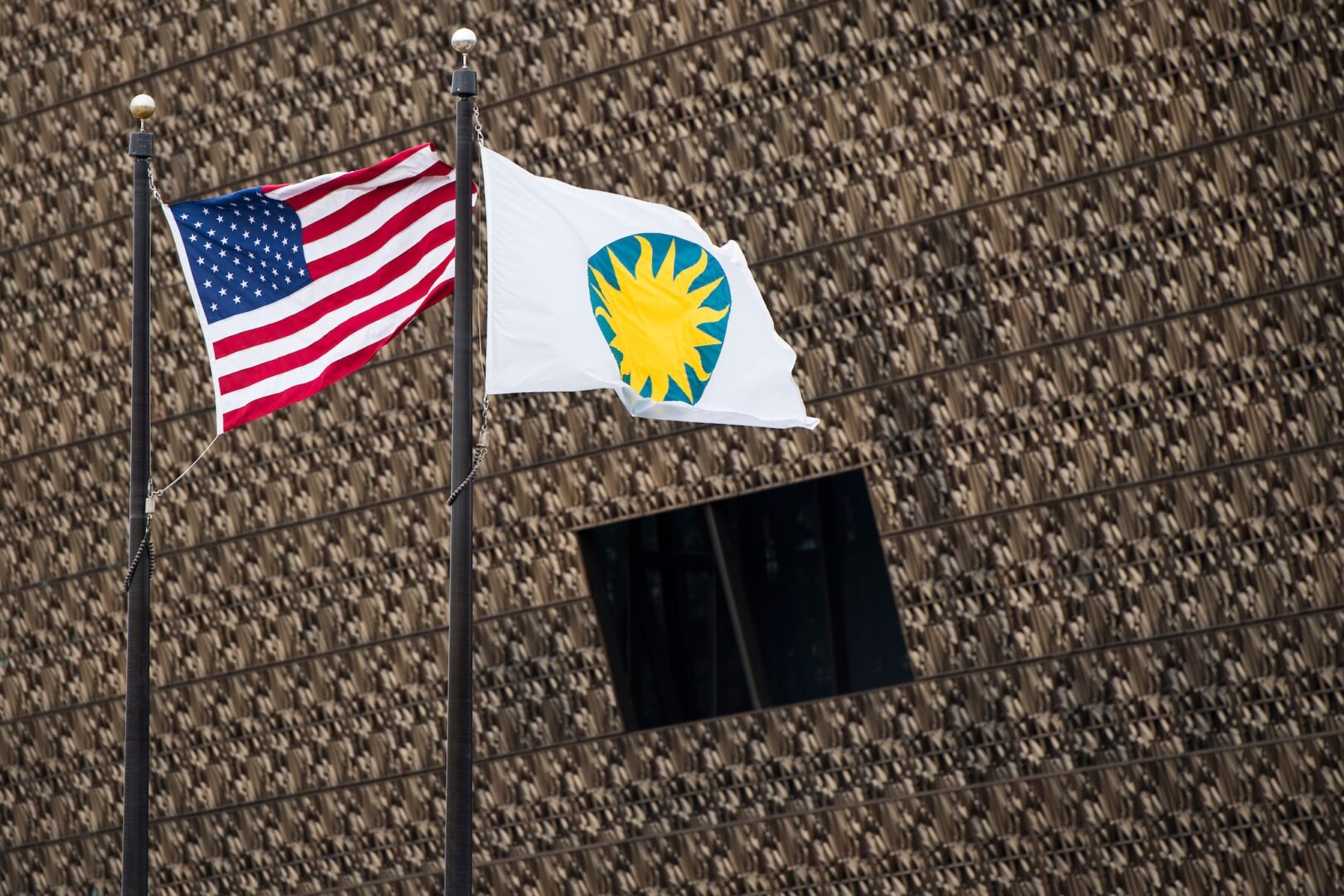 The Smithsonian and U.S. flags fly in front of the National Museum of African American History and Culture in 2019.